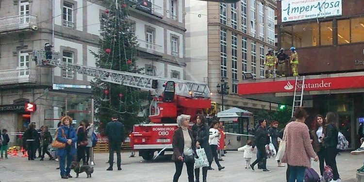 Los bomberos amarran un árbol de Navidad ante la alerta por viento