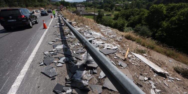 Un camión pierde su carga, planchas de granito, en la carretera de Os Valos
