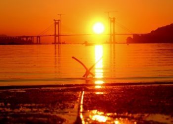 O sol baixa pola Ponte de Rande