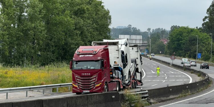 Atascado bajo un puente de la autovía un tráiler que transportaba camiones