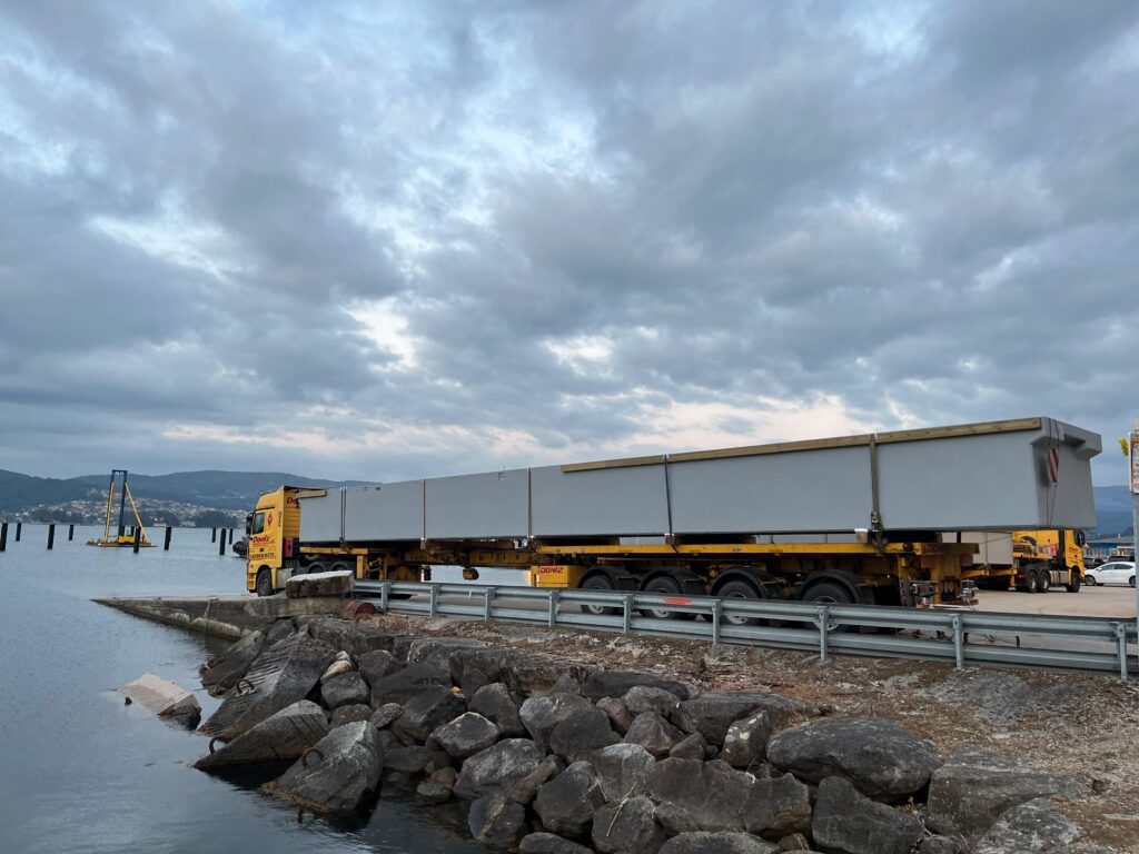 Enormes piezas de hormigón más de 20 metros de longitud viajaron esta semana desde A Coruña hasta San Adrián de Cobres. Se trata de los dos primeros pantalanes que ya se han empezado a instalar en el nuevo puerto de bateeiros de la ría de Vigo.