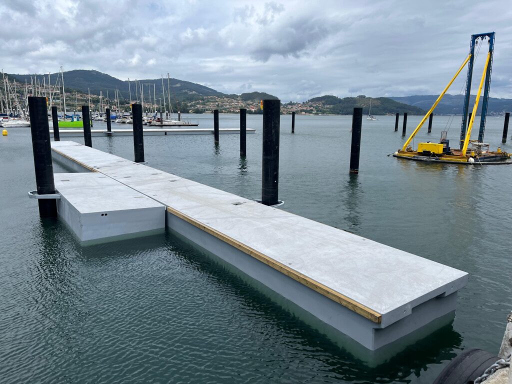 Enormes piezas de hormigón más de 20 metros de longitud viajaron esta semana desde A Coruña hasta San Adrián de Cobres. Se trata de los dos primeros pantalanes que ya se han empezado a instalar en el nuevo puerto de bateeiros de la ría de Vigo.
